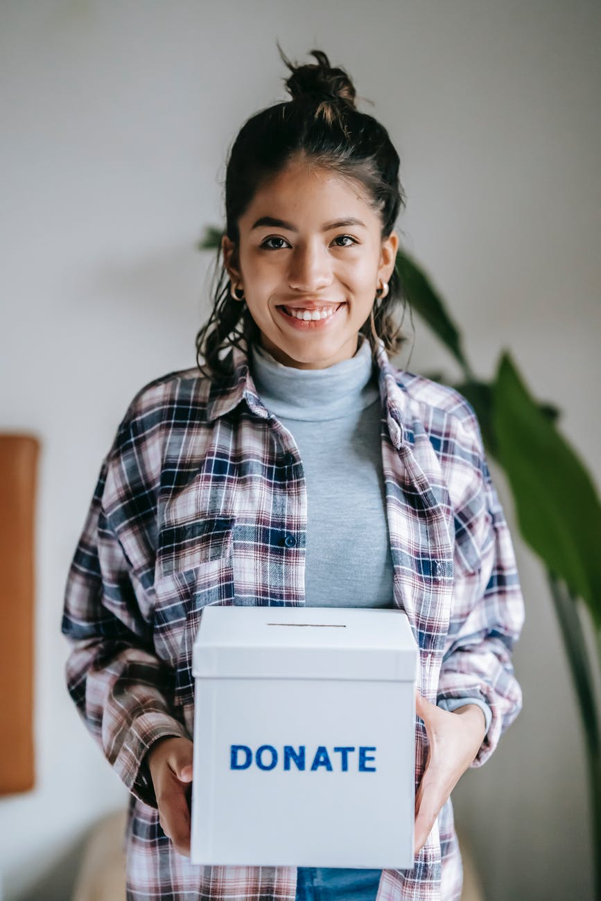 cheerful ethnic woman with donate box