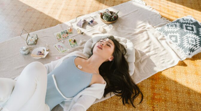 serene asian woman lying with chakra stone on chest